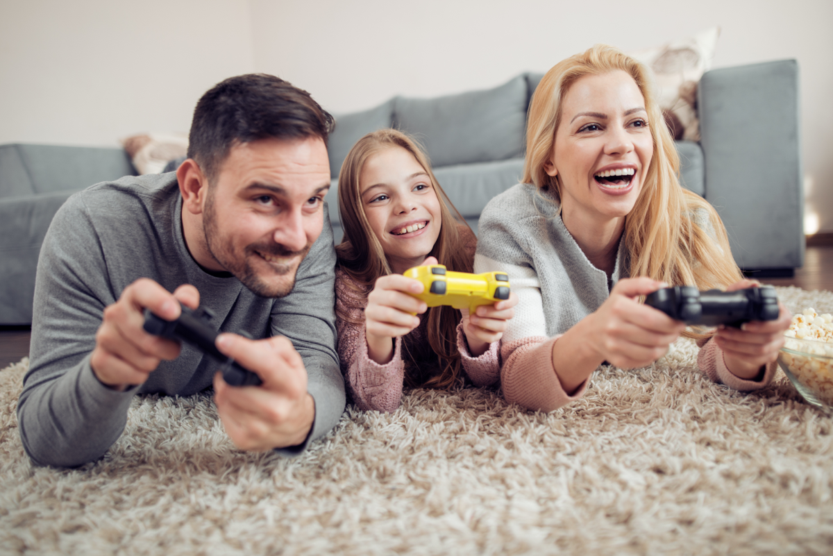 Family playing video games together on living room floor